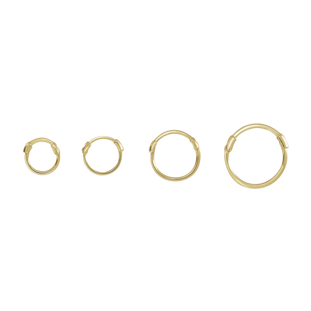 Four gold thin huggie hoop earrings in increasing sizes displayed on white background