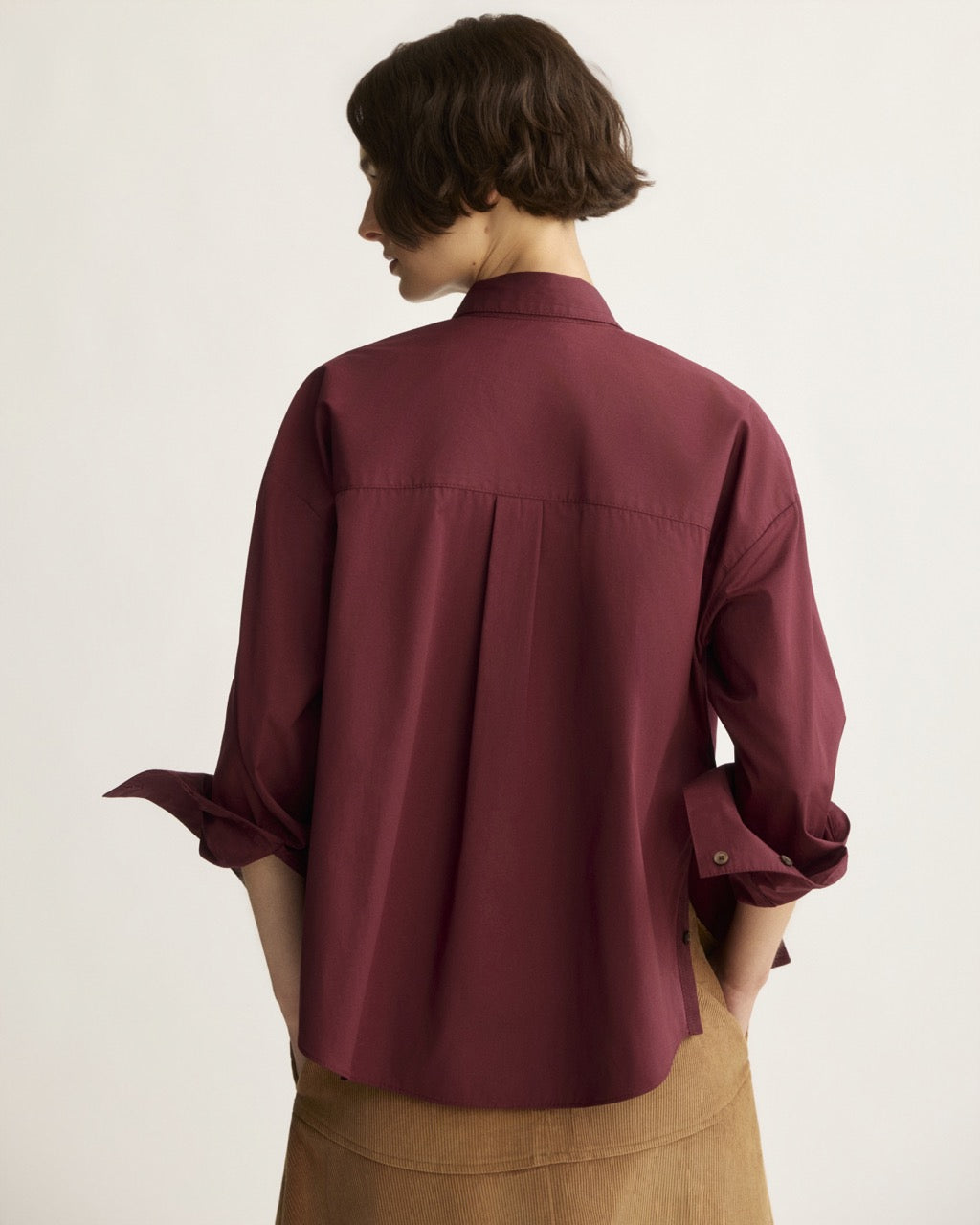 Back view of oversized berry cotton button-up shirt with rolled sleeves and back pleat
