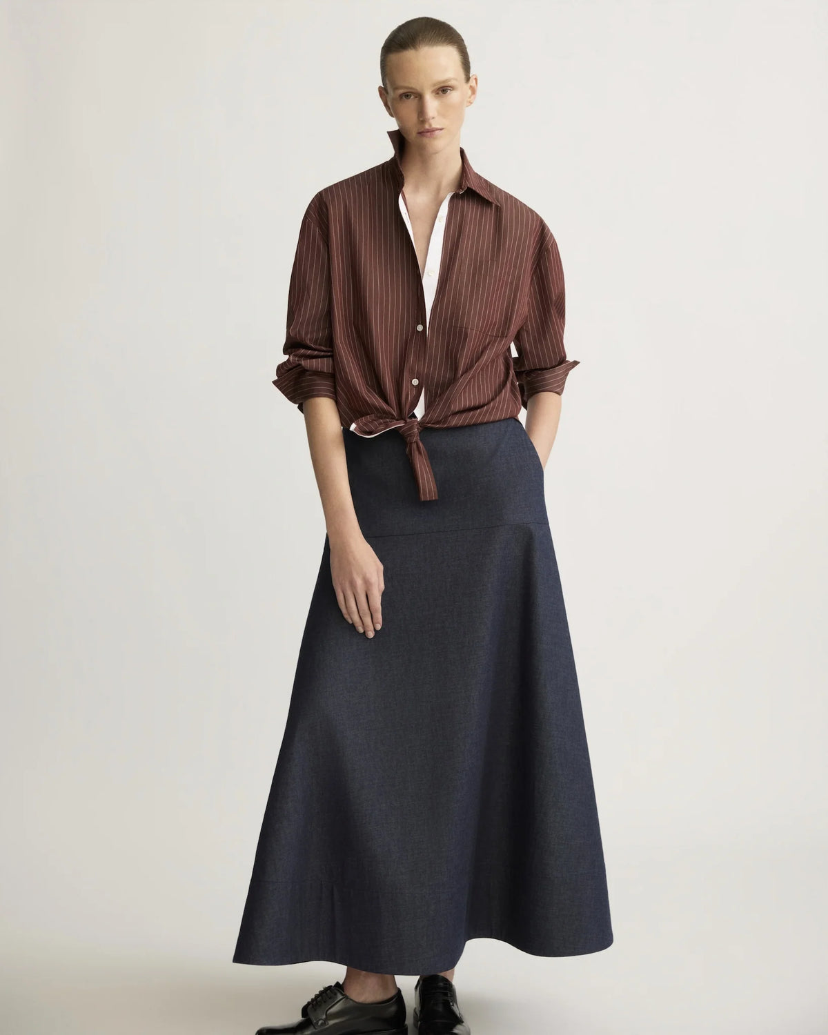 Oxblood striped oversized boyfriend shirt tied at waist, worn with navy maxi skirt