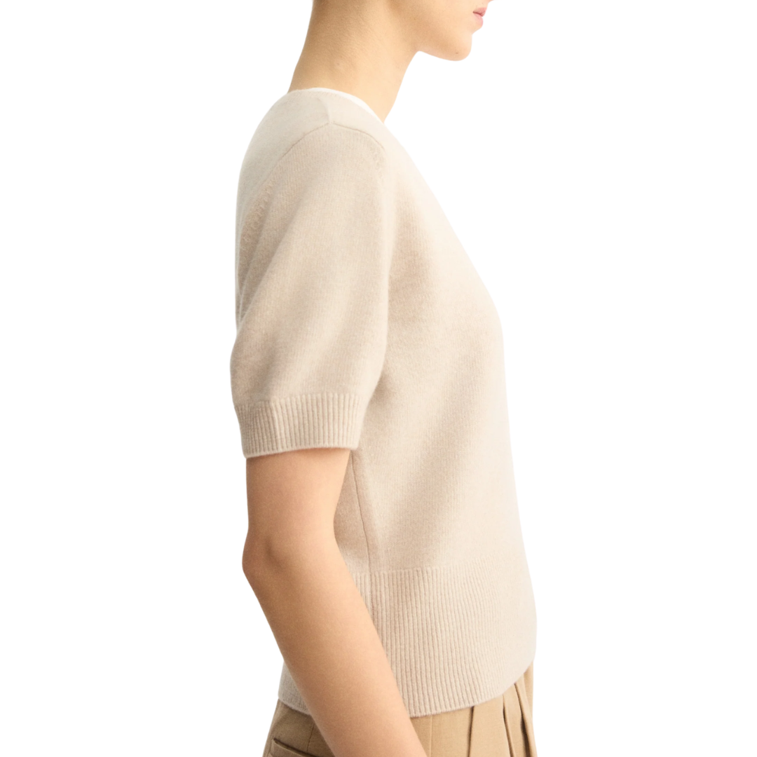 Model wearing beige short sleeve crew neck sweater in side profile