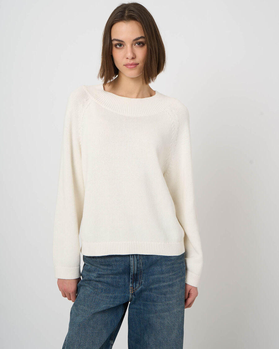 Cropped cream cashmere-cotton sweater with boat neckline and raglan sleeves paired with blue jeans