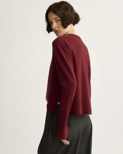 Berry red cashmere crewneck sweater, back view, worn with black trousers