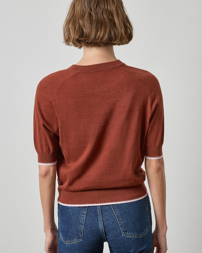 Rust brown short-sleeve crewneck knit sweater with white tipped hem and cuffs