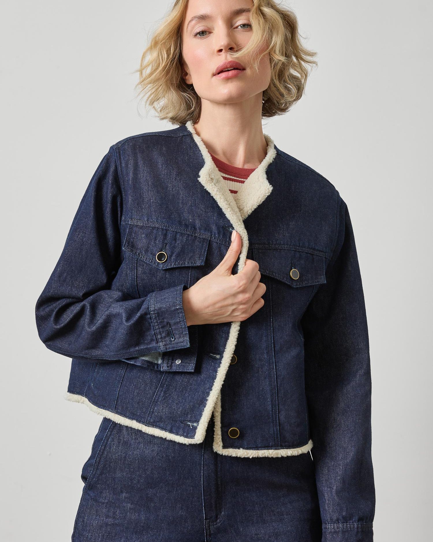 Dark wash denim jacket with cream sherpa lining and snap button closure
