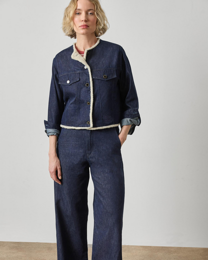 Dark wash blue denim jacket with cream sherpa trim and snap buttons