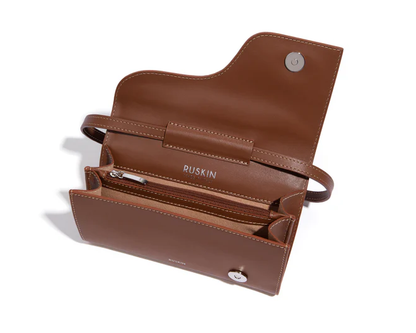 Open brown leather mini bag showing interior zipper pocket and snap closure by Ruskin