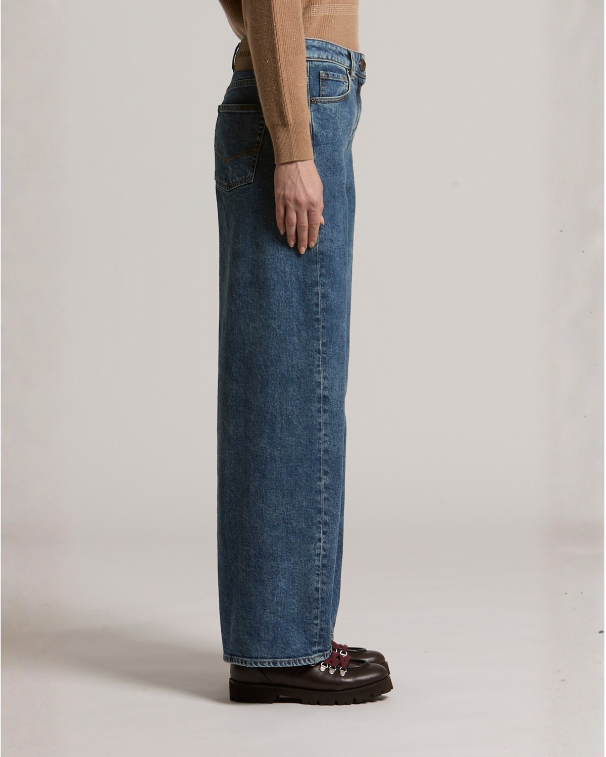 Wide-leg medium blue denim jeans with side seam detail, worn with dark boots