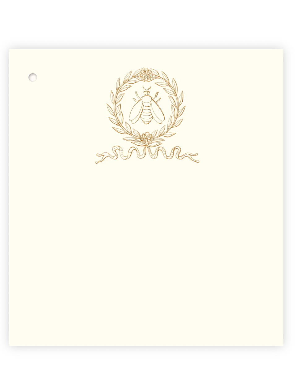 Ecru gift tag with gold bee crest wreath and ribbon illustration, hole punched