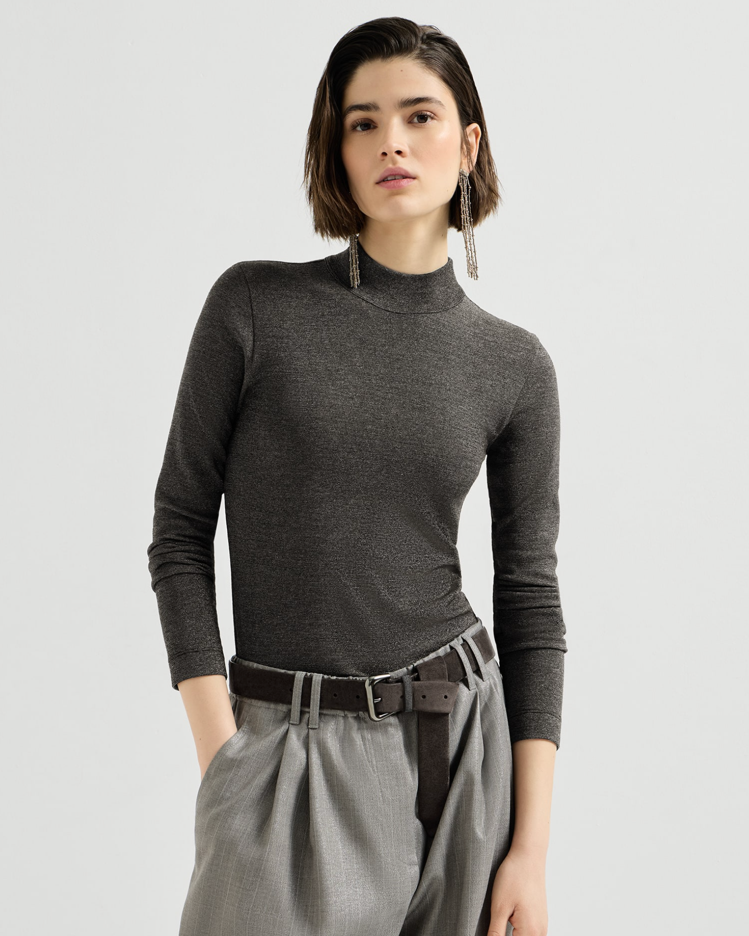 Fitted anthracite silver mockneck long-sleeve top with subtle shimmer, styled with gray trousers