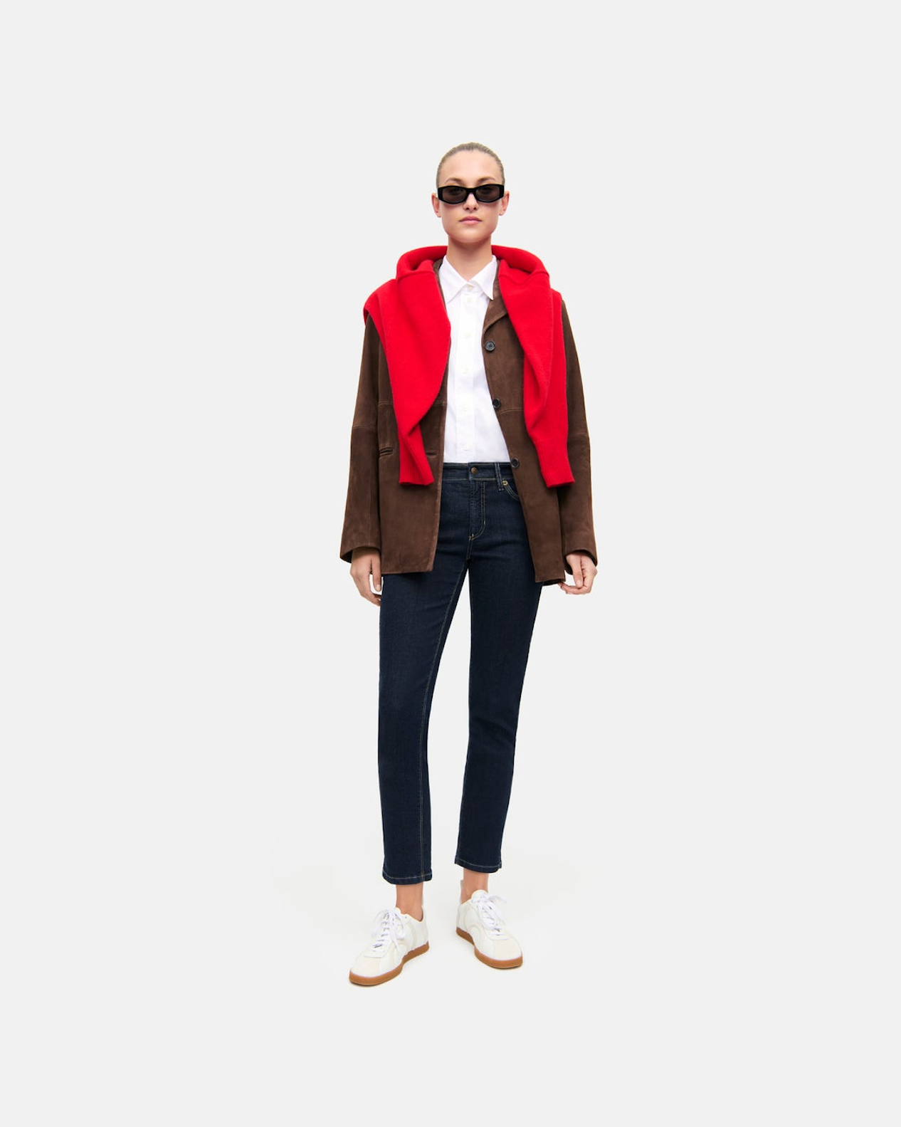 Dark rinse slim straight jeans worn with brown jacket and red hoodie