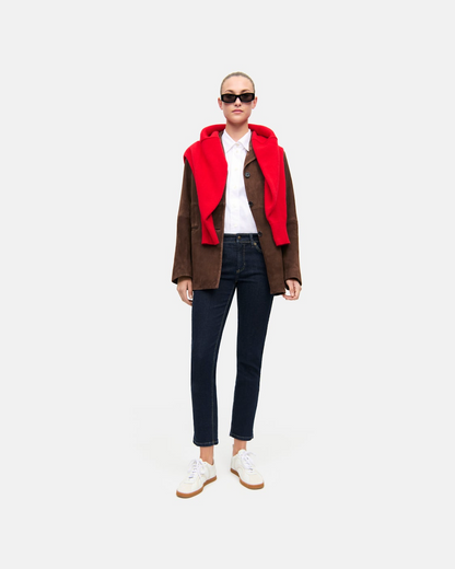 Dark rinse slim straight jeans worn with brown jacket and red hoodie