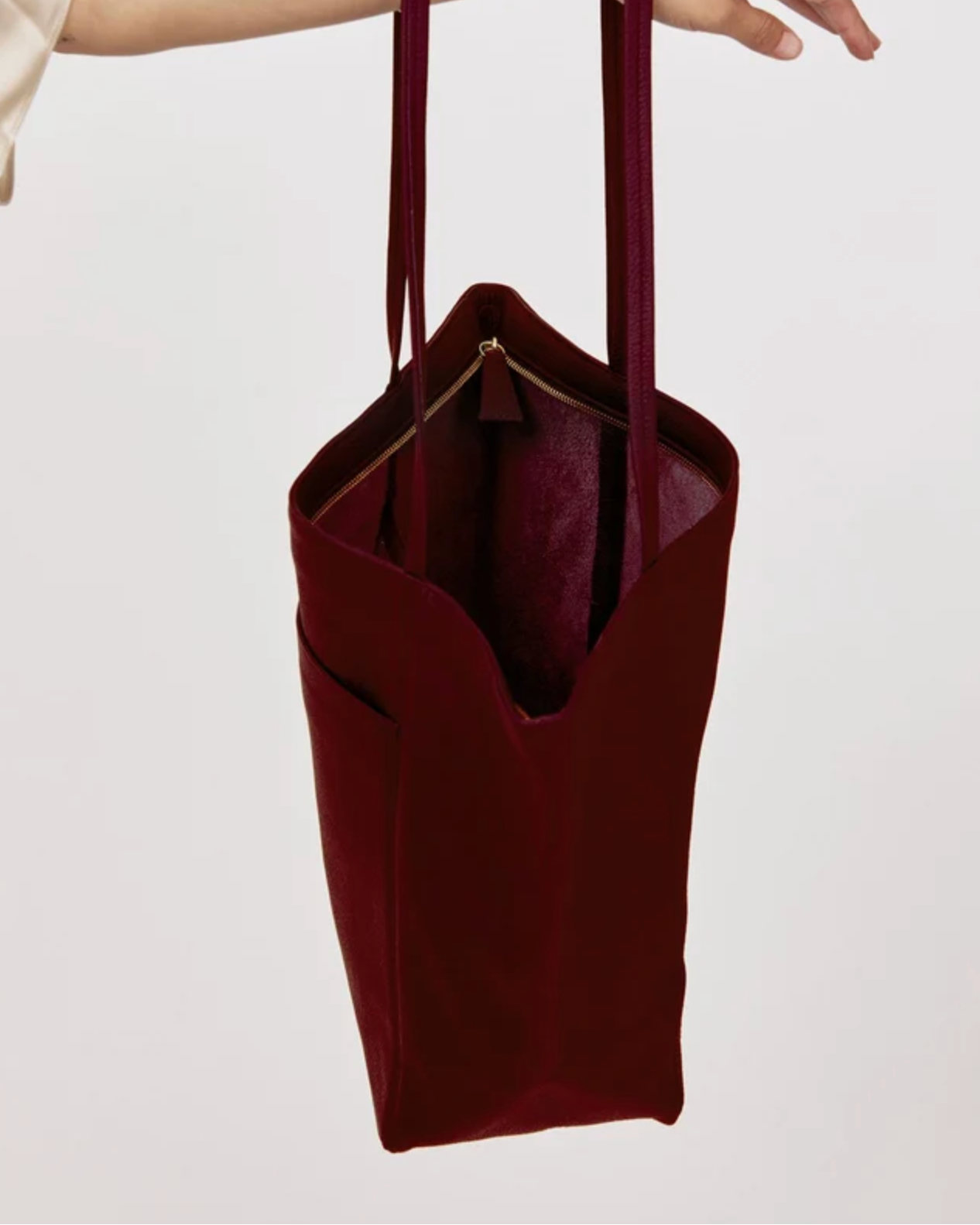 Plum suede tote bag with gold zipper pocket and long shoulder straps