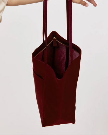 Plum suede tote bag with gold zipper pocket and long shoulder straps