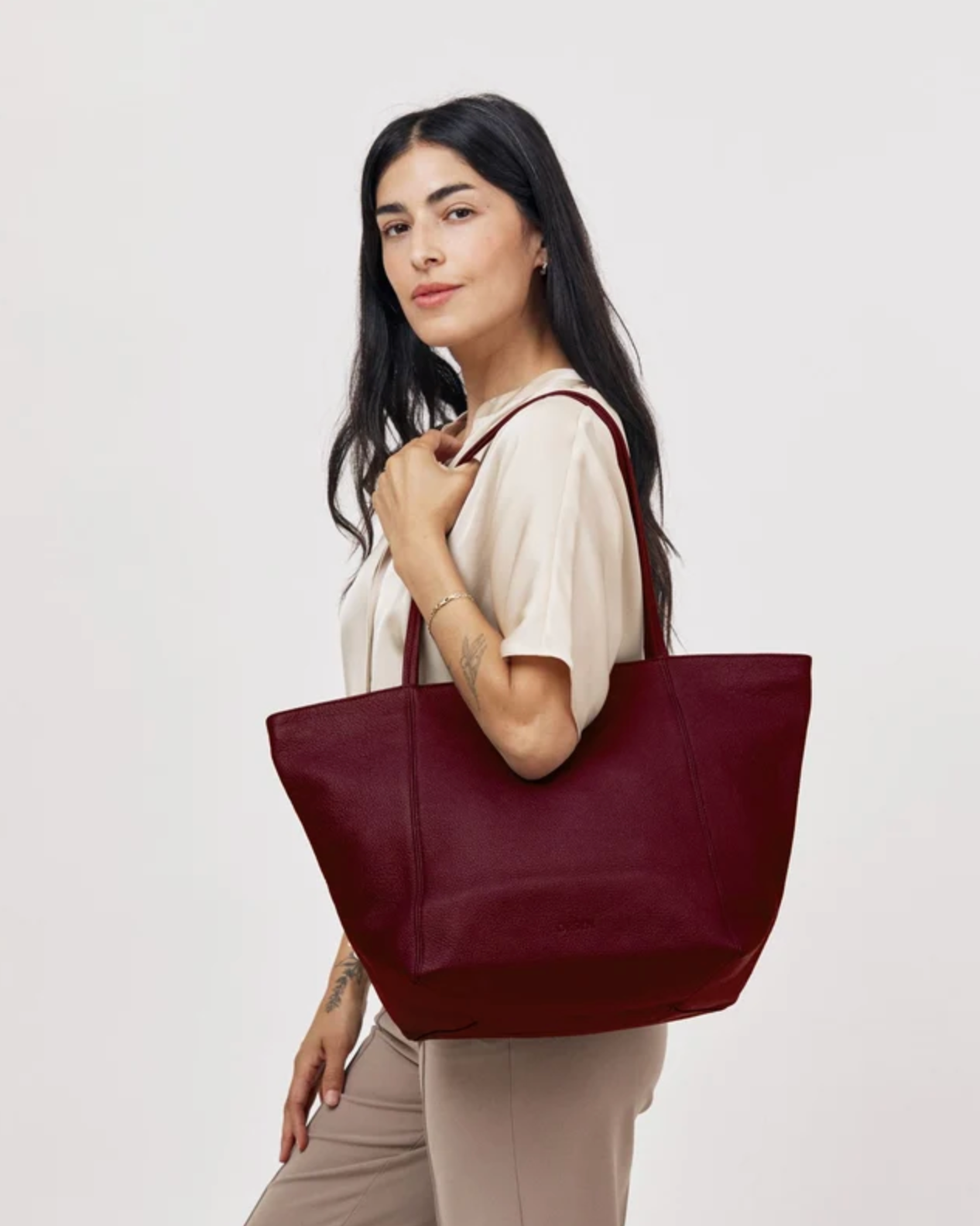 Vienna Tote in plum pebble grain leather carried on shoulder by female model