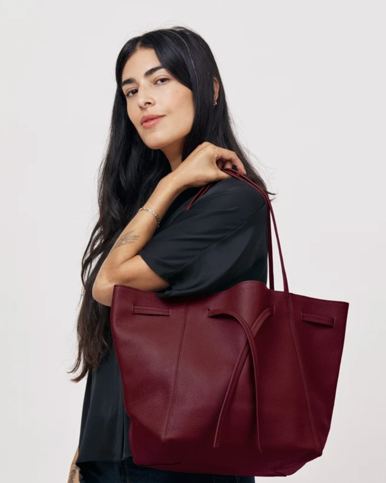Florence Tote in Plum Pebble Grain leather with bow detail, carried on shoulder