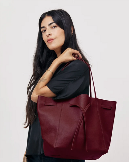 Florence Tote in Plum Pebble Grain leather with bow detail, carried on shoulder