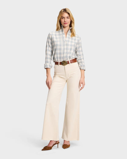 Light blue plaid flannel shirt with rolled sleeves, tucked into cream wide-leg jeans