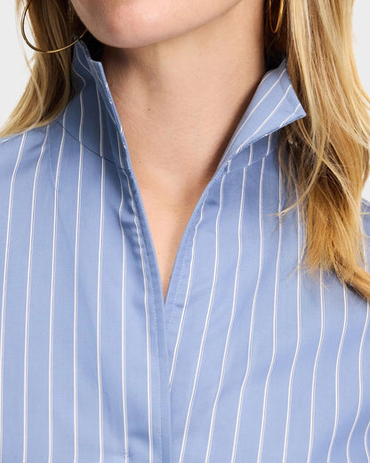 Blue pinstripe button-up shirt with open collar, worn by blonde woman with gold hoop earrings