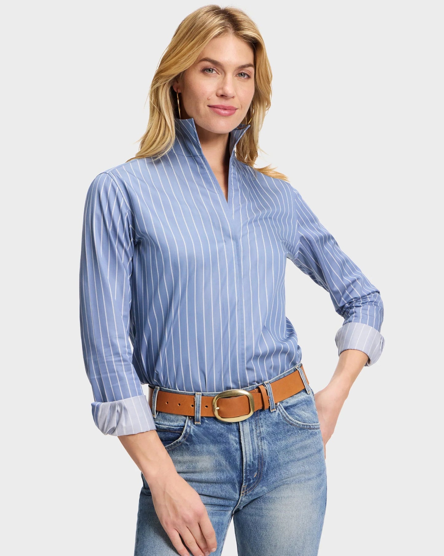 Blue pinstripe popover blouse with mock collar and rolled cuffs, tucked into jeans
