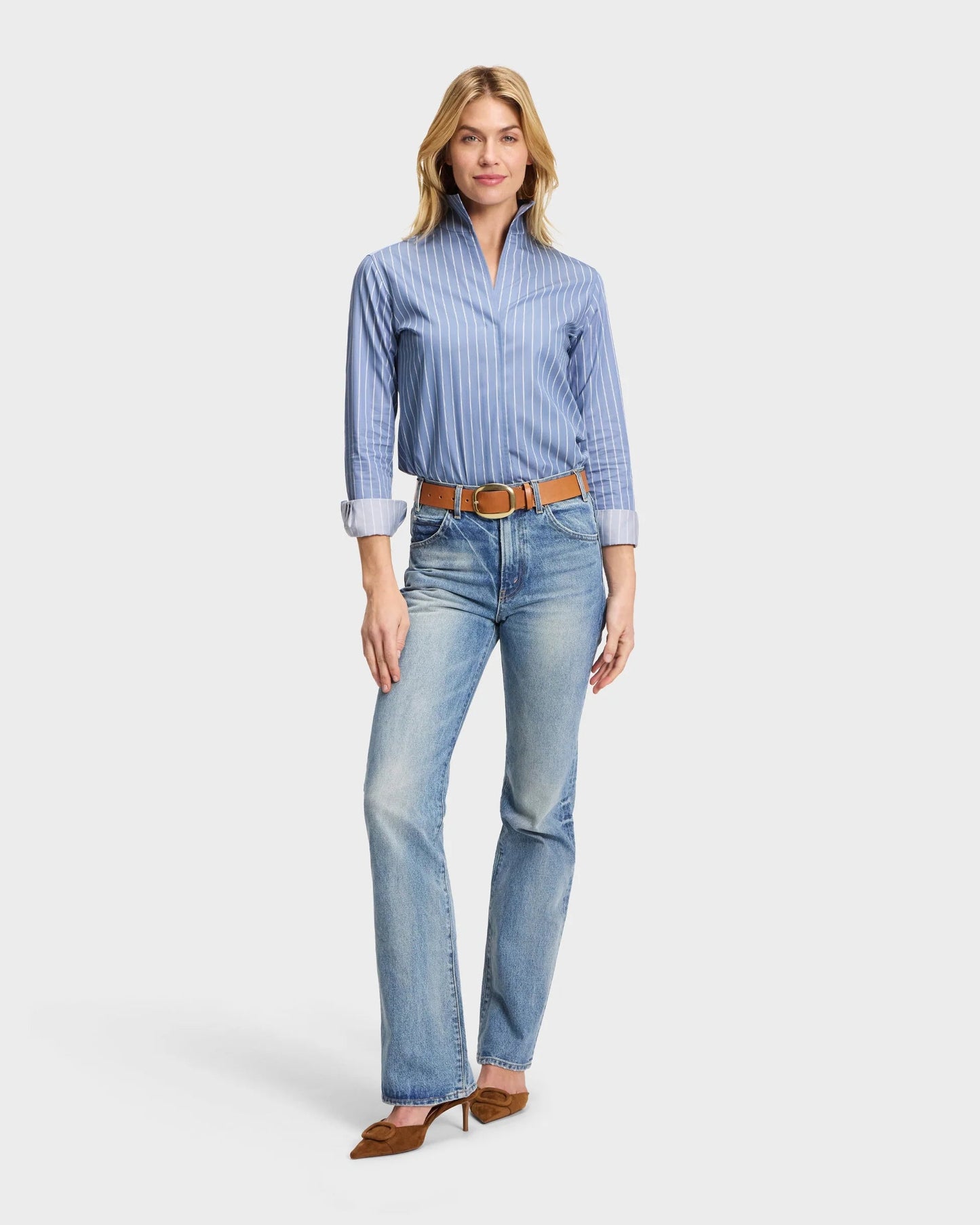 Blue pinstripe Portofino shirt with stand collar, tucked into light wash bootcut jeans