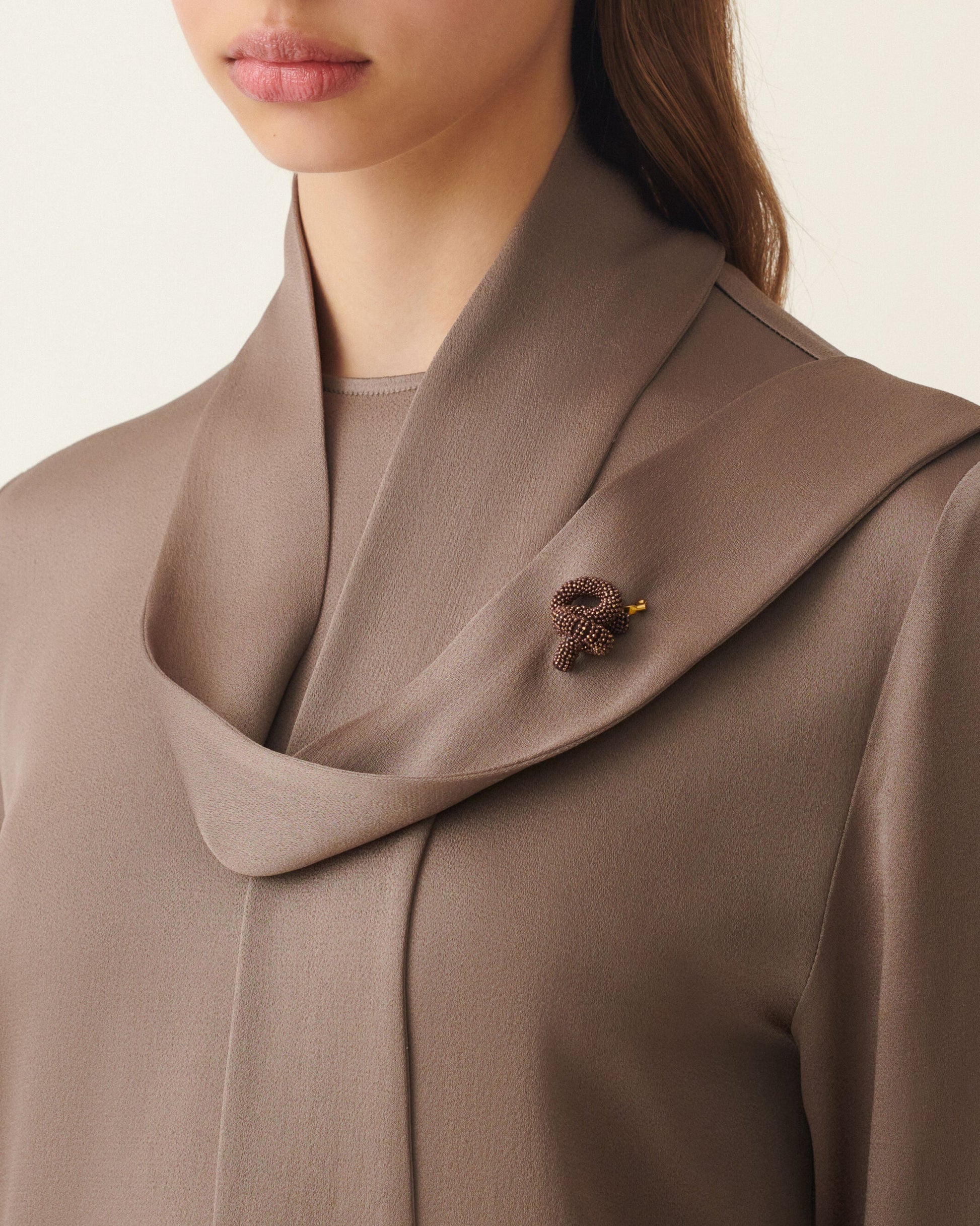 Taupe satin draped collar top with small brown beaded brooch accent