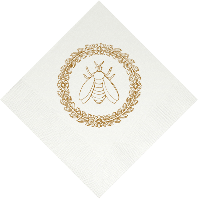 Elegant white beverage napkin featuring gold bee emblem surrounded by decorative wreath