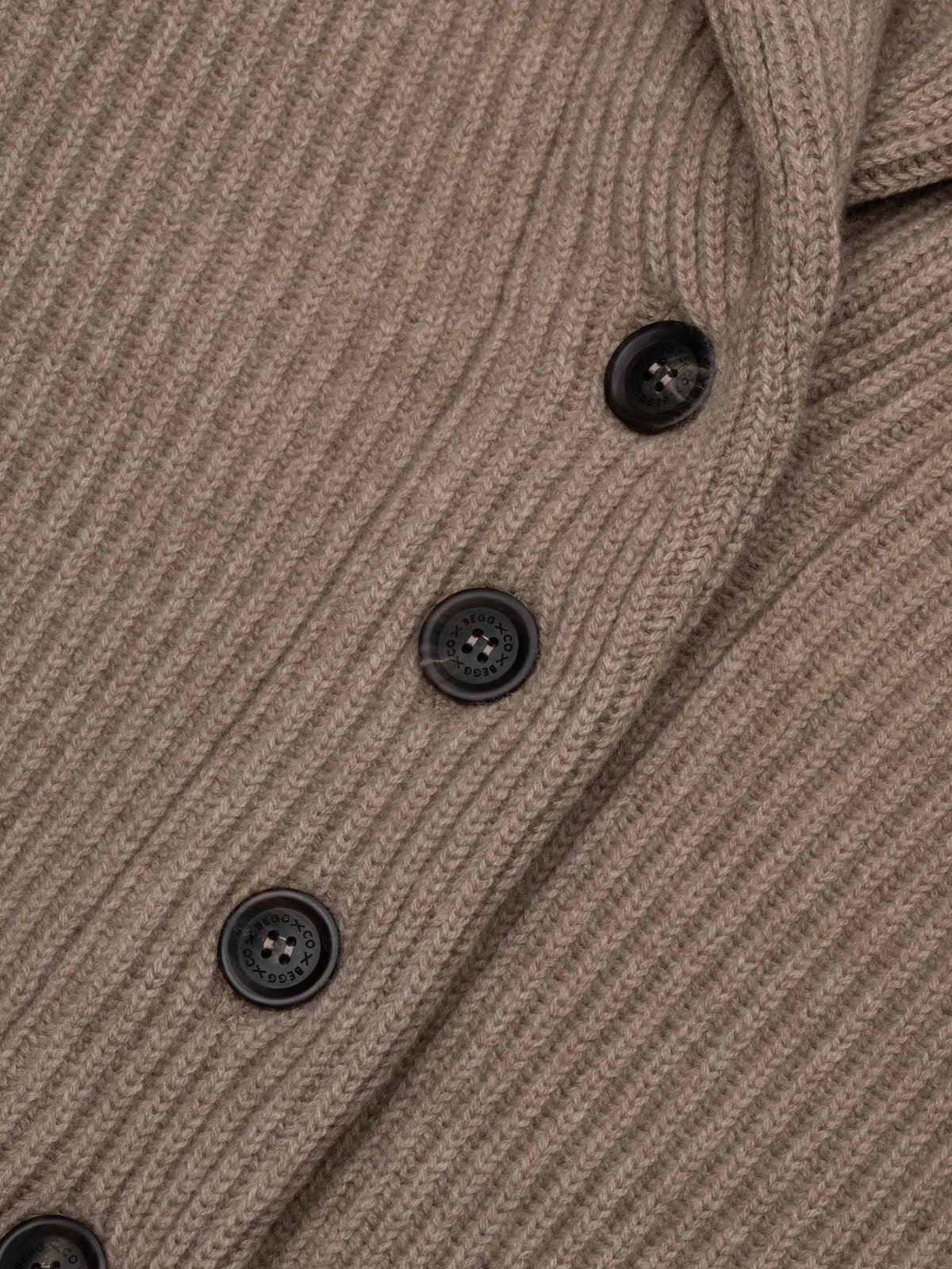 Close-up detail of ribbed knit cardigan with dark buttons in brown undyed colorway